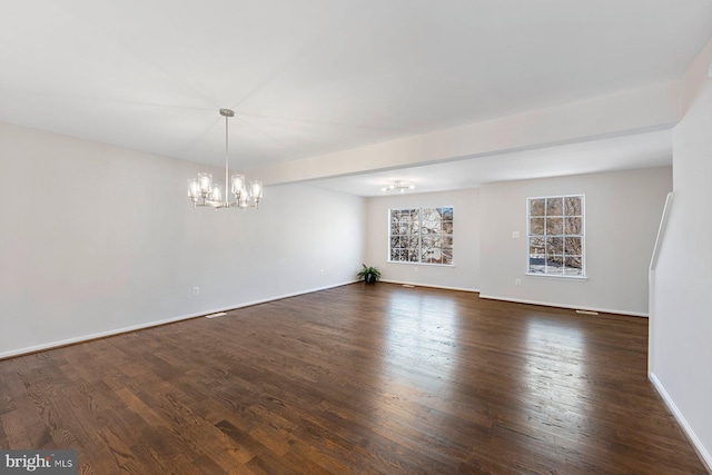 empty room with dark hardwood / wood-style floors and a chandelier