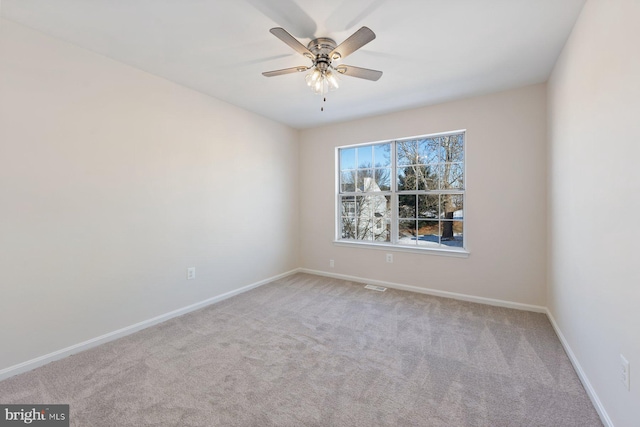 carpeted spare room with ceiling fan