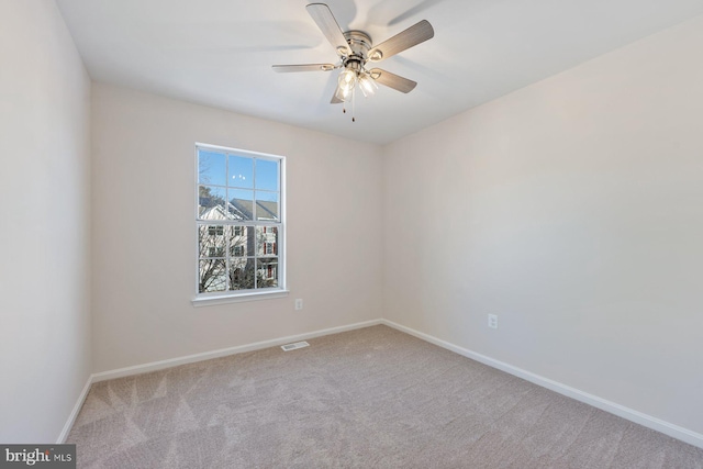 spare room featuring ceiling fan and light carpet