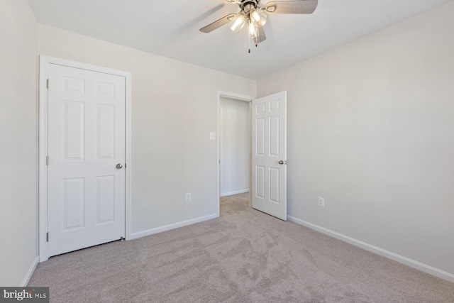 unfurnished bedroom featuring light carpet and ceiling fan