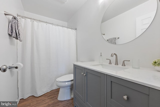 bathroom with hardwood / wood-style floors, toilet, and vanity