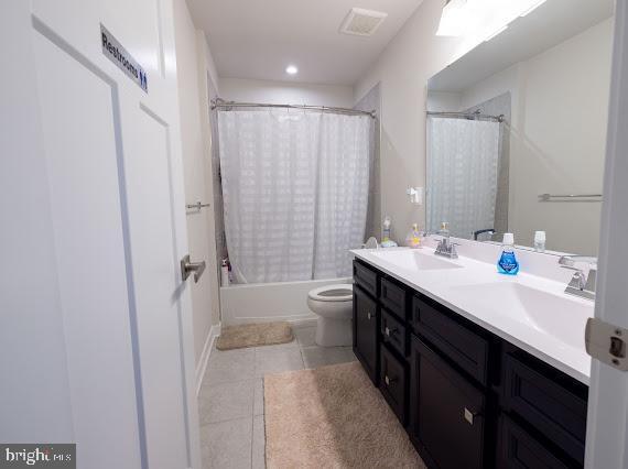 full bathroom with tile patterned flooring, vanity, toilet, and shower / bathtub combination with curtain