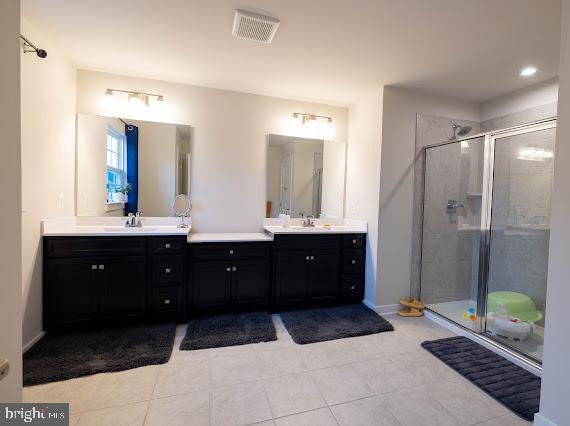 bathroom with vanity, tile patterned floors, and a shower with door