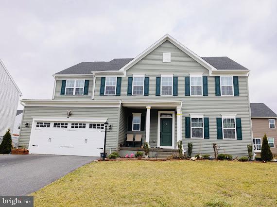 view of front facade with a front yard, a porch, and a garage