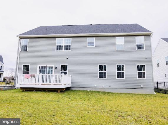 back of property featuring a lawn and a wooden deck