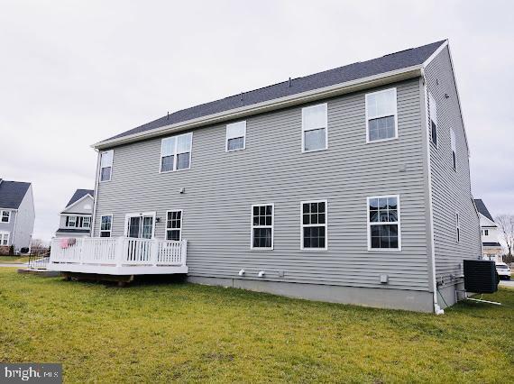 back of house featuring a lawn, central AC unit, and a wooden deck