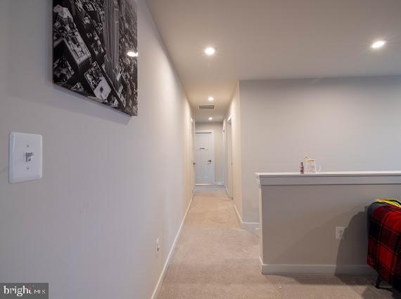 hallway featuring light colored carpet