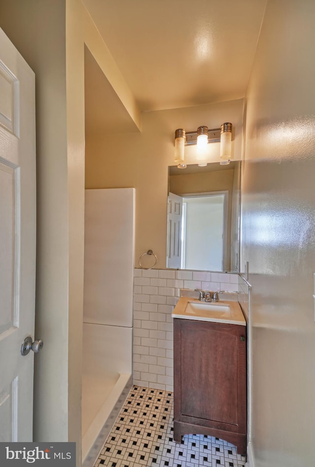 bathroom featuring a shower, vanity, tile patterned floors, and tile walls