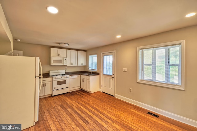 kitchen featuring white appliances, light hardwood / wood-style flooring, white cabinetry, and sink