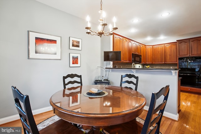 dining room with light hardwood / wood-style floors and a chandelier