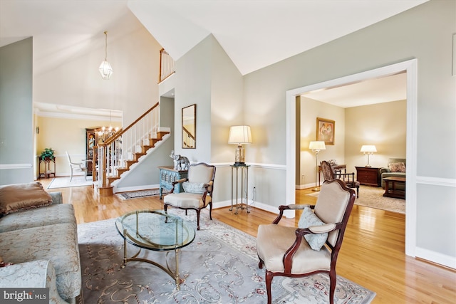 living room with a chandelier, light hardwood / wood-style floors, and lofted ceiling