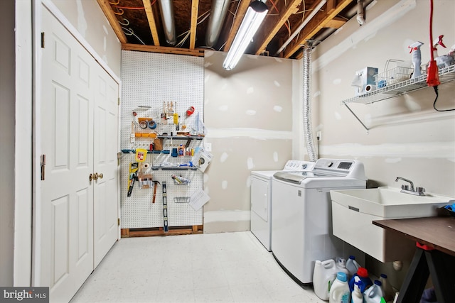 laundry room with a workshop area, sink, and washing machine and dryer