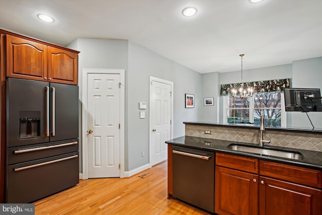 kitchen with backsplash, sink, decorative light fixtures, stainless steel appliances, and a chandelier