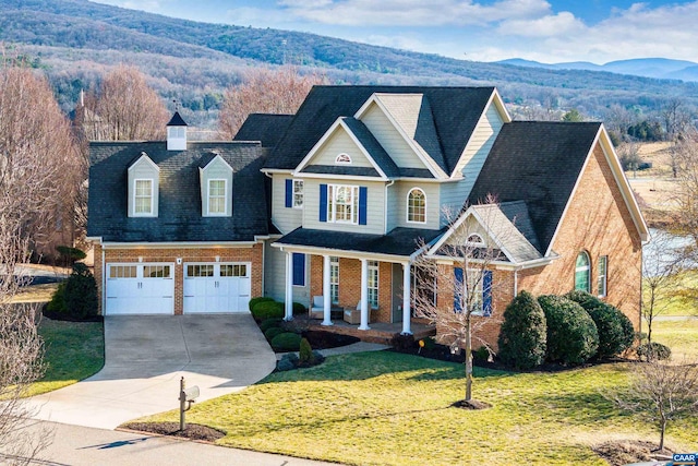 view of front of home with a mountain view, a front lawn, a porch, and a garage