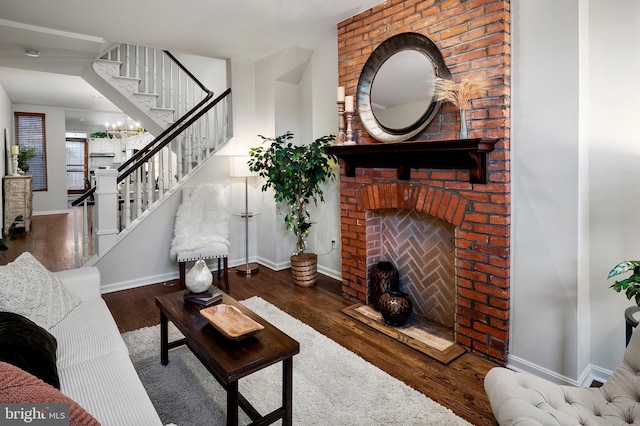 living room featuring wood-type flooring and a brick fireplace