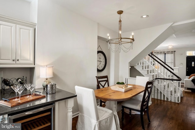 dining area with a notable chandelier, dark hardwood / wood-style flooring, wine cooler, and bar area