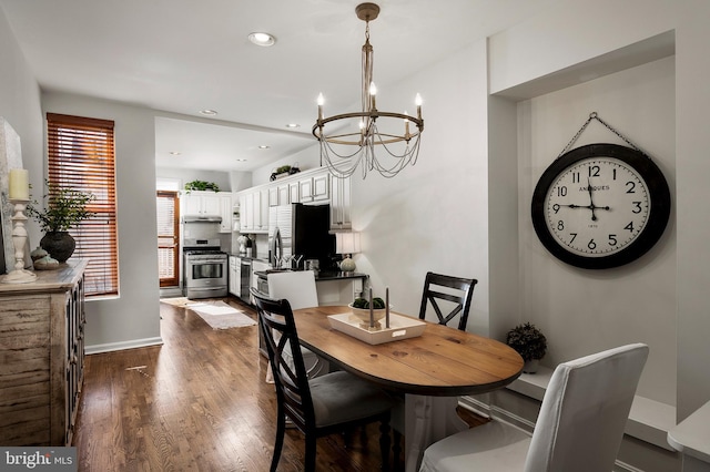 dining area featuring dark hardwood / wood-style flooring and an inviting chandelier