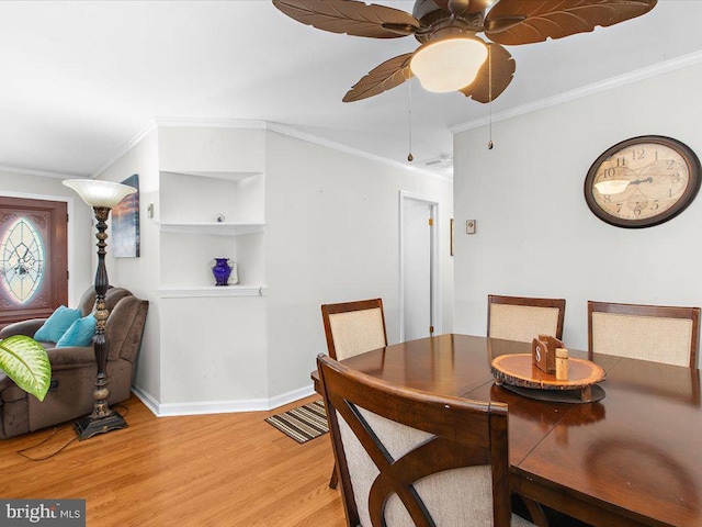 dining area with crown molding, ceiling fan, and wood-type flooring