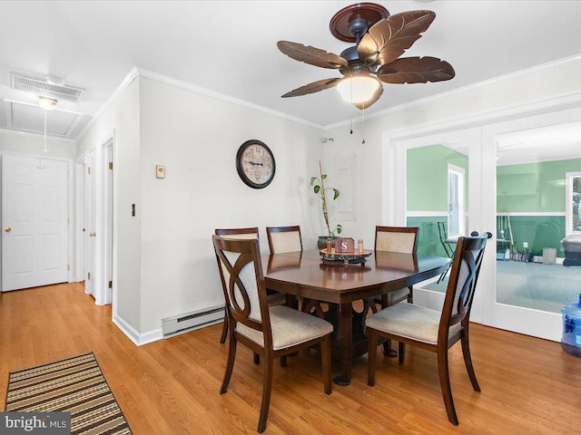 dining space featuring ceiling fan, light hardwood / wood-style floors, crown molding, and a baseboard heating unit