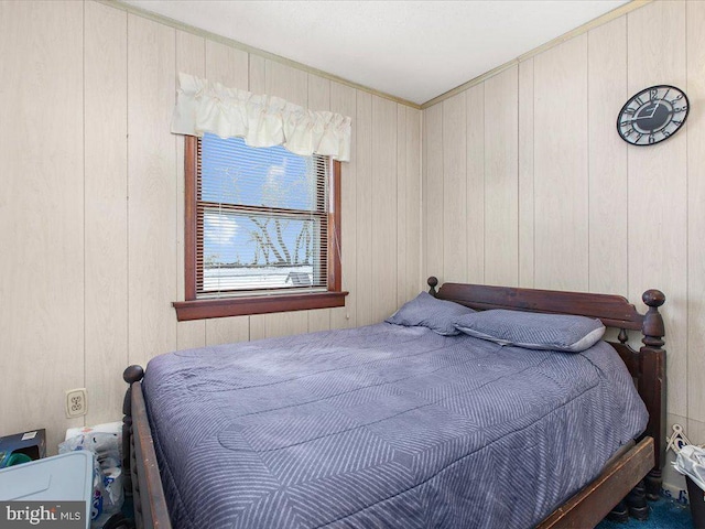 bedroom featuring wooden walls