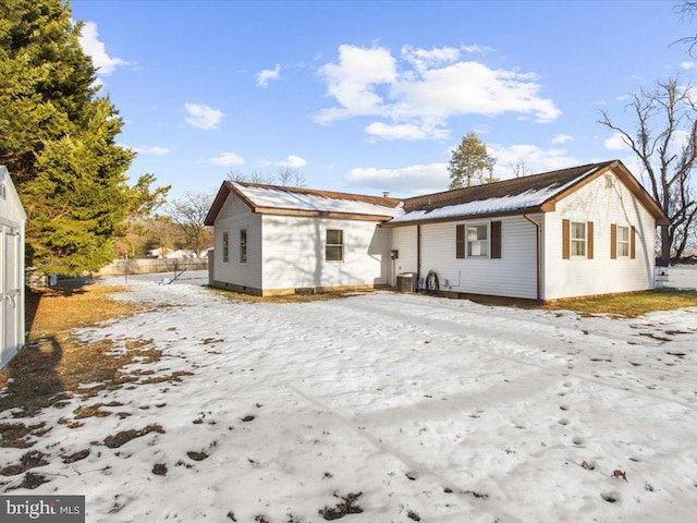 snow covered rear of property with central AC unit