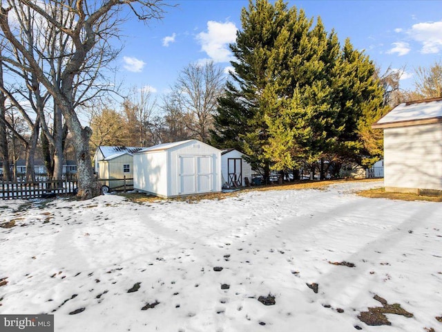 yard layered in snow featuring a storage shed