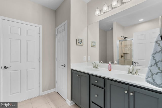 bathroom featuring tile patterned flooring, vanity, and a shower with shower door