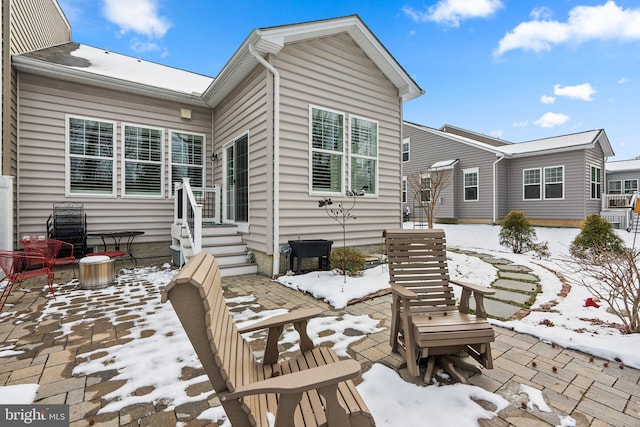 snow covered property with a patio