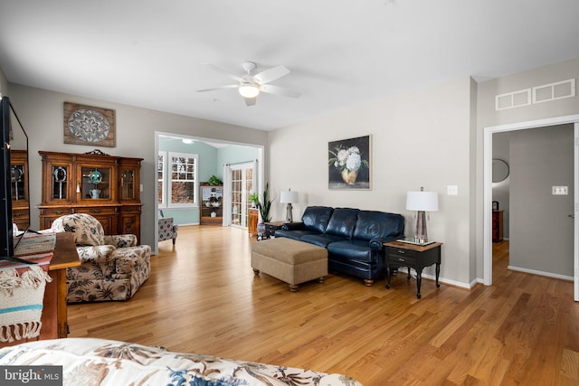 living room featuring ceiling fan and light hardwood / wood-style floors