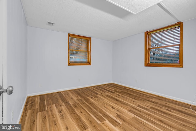 spare room with hardwood / wood-style flooring and a textured ceiling