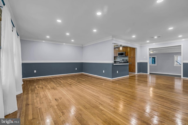 unfurnished living room featuring ornamental molding and light hardwood / wood-style floors