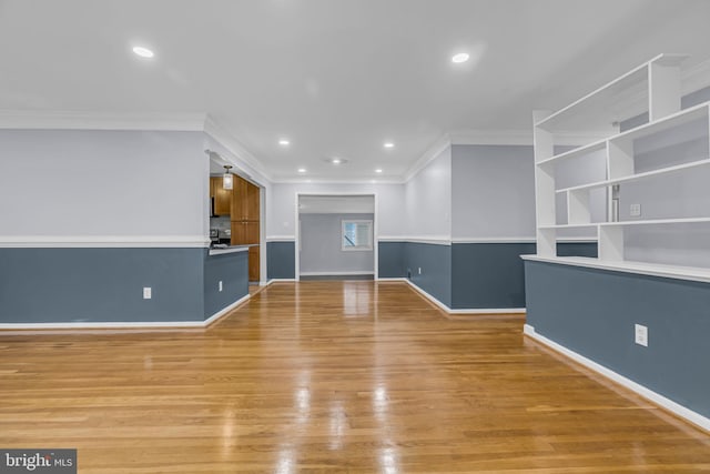 unfurnished living room featuring crown molding and light hardwood / wood-style flooring