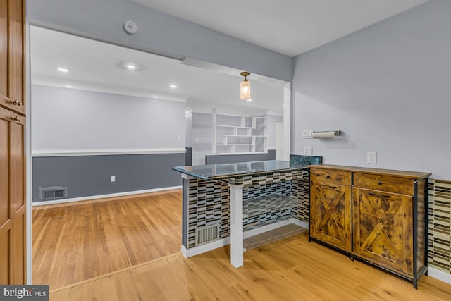 kitchen featuring kitchen peninsula and light hardwood / wood-style flooring