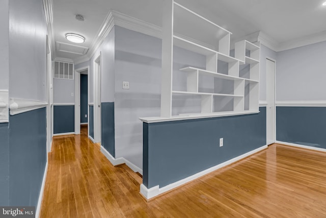 hall with crown molding, wood-type flooring, and built in shelves