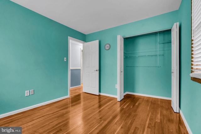 unfurnished bedroom with hardwood / wood-style floors and a closet