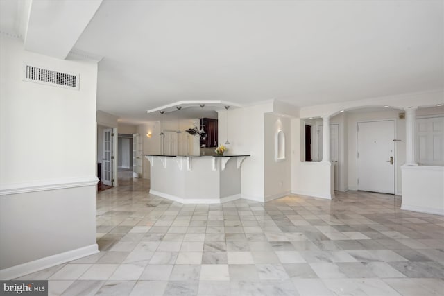 unfurnished living room with decorative columns