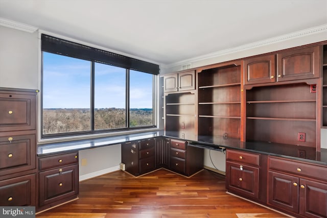 unfurnished office with crown molding, dark wood-type flooring, and built in desk