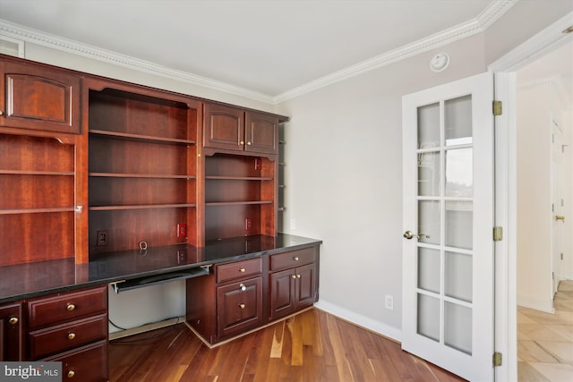 office with crown molding, wood-type flooring, and built in desk