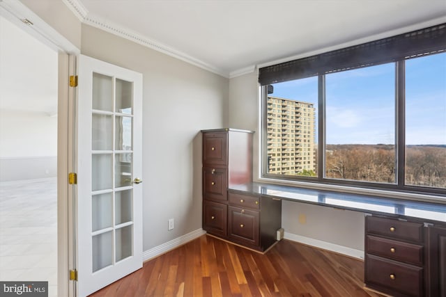 unfurnished office with ornamental molding, dark hardwood / wood-style flooring, and built in desk