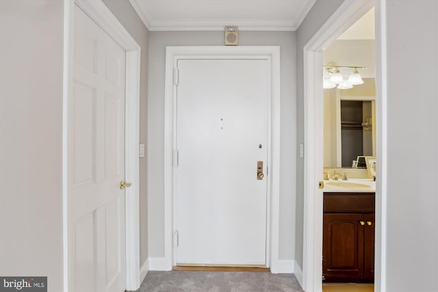 doorway to outside with crown molding, sink, and light carpet