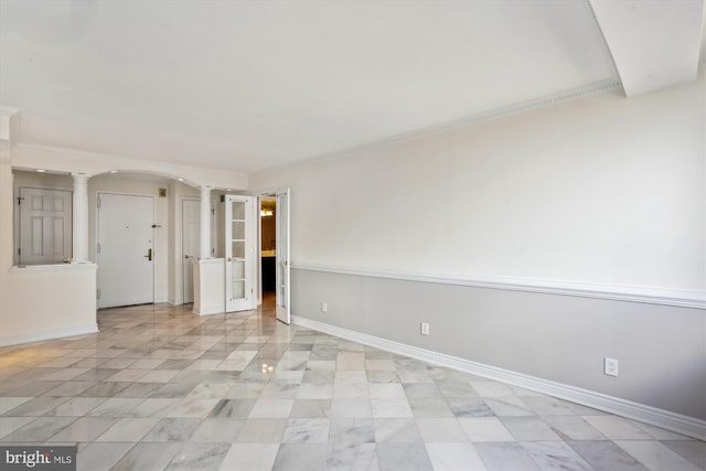 spare room featuring decorative columns