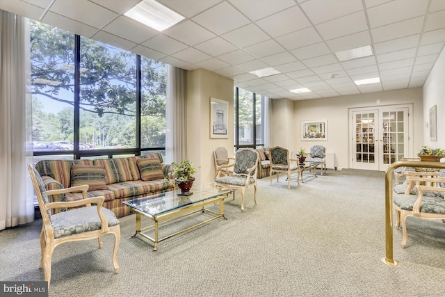 carpeted living room featuring expansive windows, a paneled ceiling, a wealth of natural light, and french doors