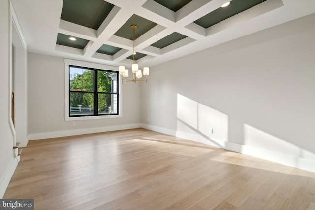 spare room with beam ceiling, light hardwood / wood-style flooring, a notable chandelier, and coffered ceiling