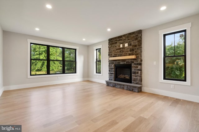 unfurnished living room featuring light wood-type flooring and a fireplace