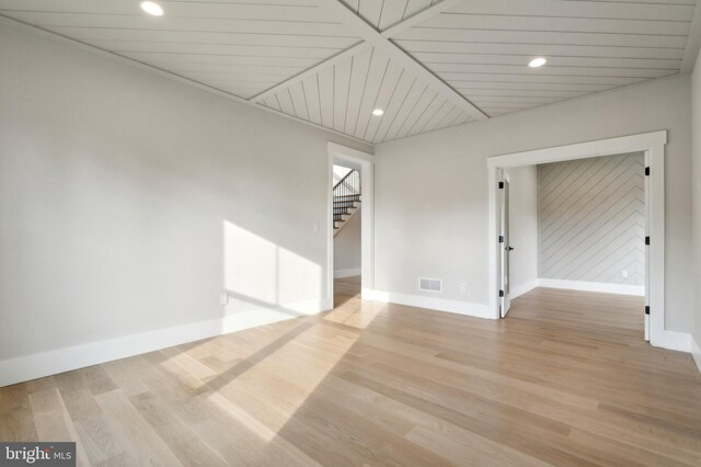 unfurnished room with light hardwood / wood-style flooring and wooden ceiling