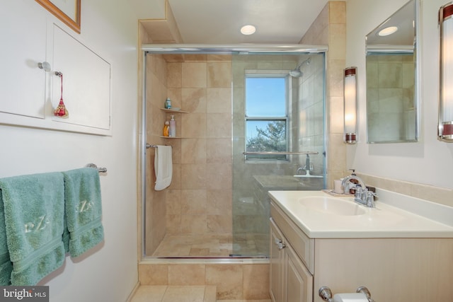 bathroom with tile patterned flooring, vanity, and a shower with shower door