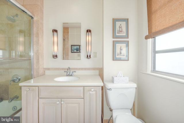 full bathroom featuring combined bath / shower with glass door, vanity, and toilet