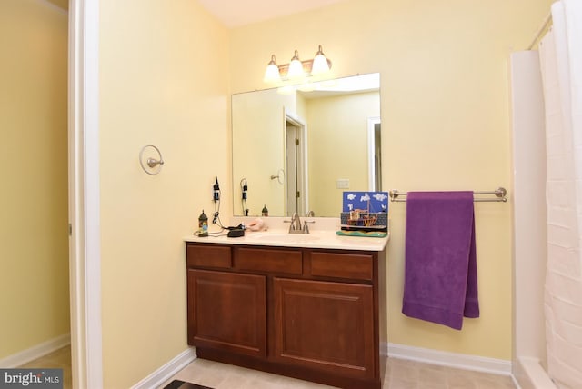 bathroom with tile patterned flooring, vanity, and walk in shower