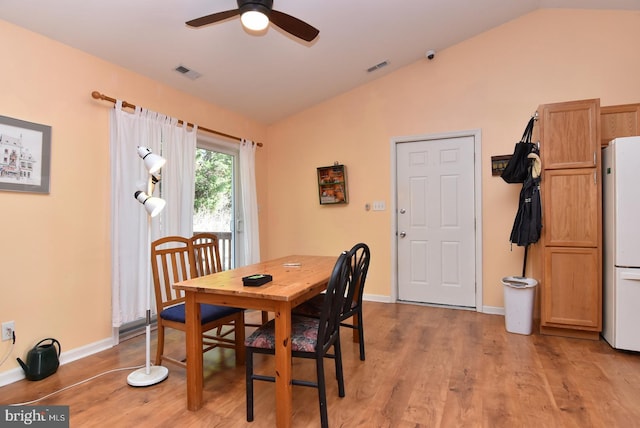 dining room featuring light hardwood / wood-style floors, vaulted ceiling, and ceiling fan