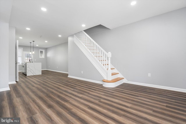 unfurnished living room featuring dark hardwood / wood-style flooring and sink